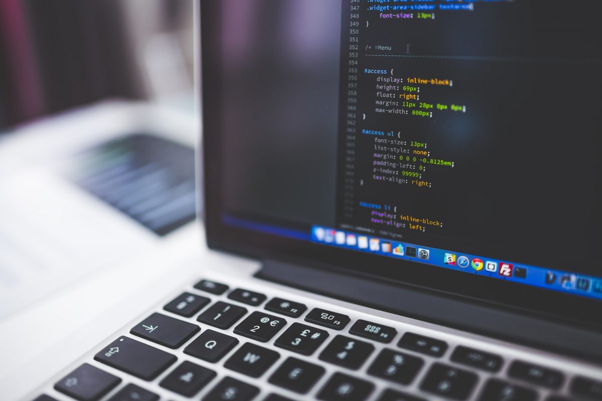 a laptop sitting on a desk showing HTML code.